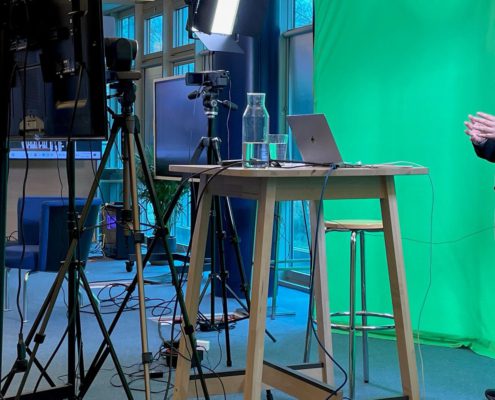 conftech-geneva-03 Furniture, Table, Desk, Adult, Male, Man, Person, Crowd, Clothing, Coat, Face, Head, Computer, Electronics, Laptop, Pc, Standing Desk