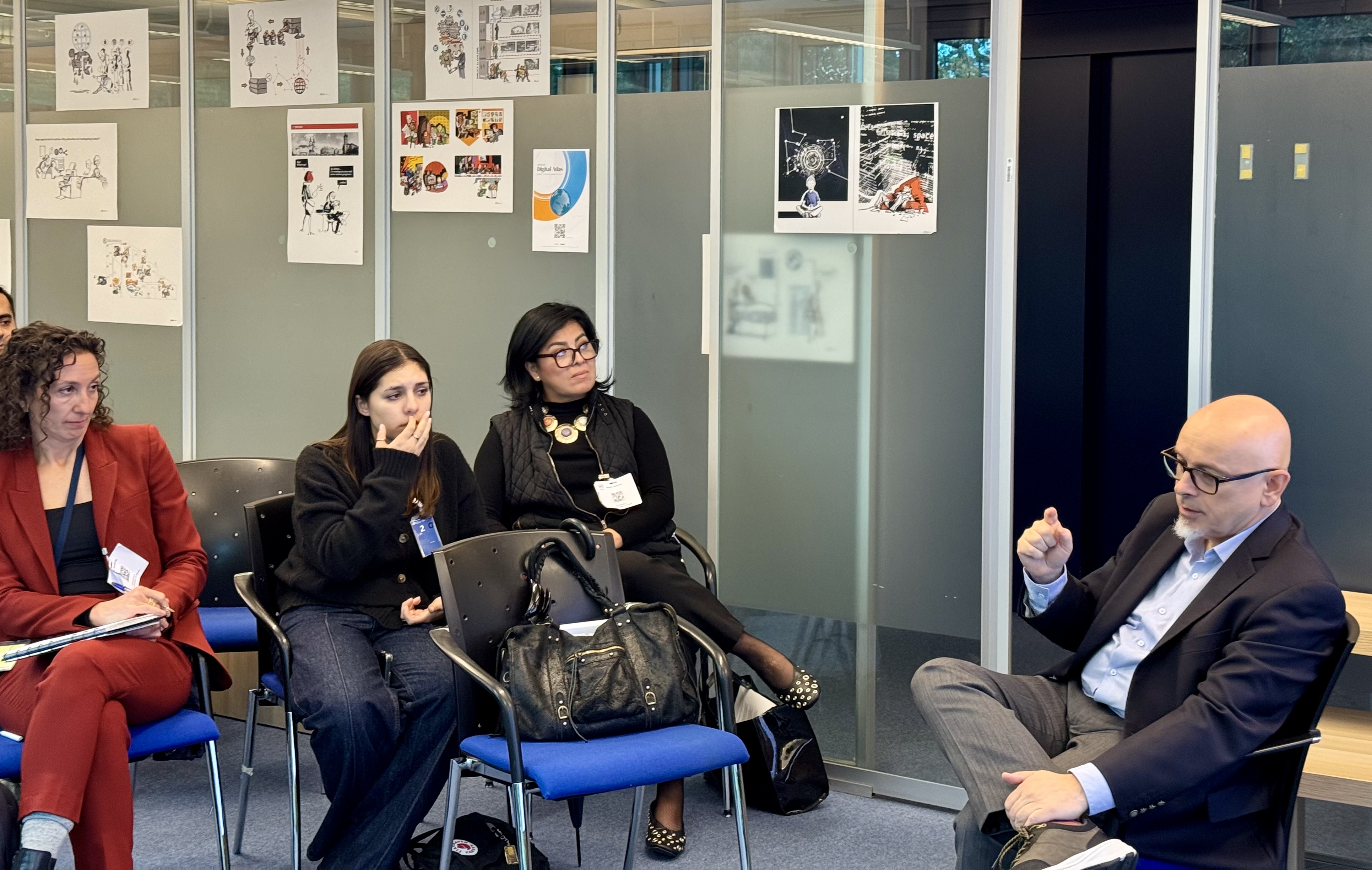  Adult, Female, Person, Woman, Accessories, Bag, Handbag, Male, Man, Chair, Furniture, Glasses, Clothing, Footwear, Shoe, Jewelry, Necklace, Conversation, People, Indoors, Crowd, Face, Head